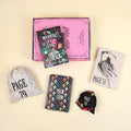 A paperback edition of The Wondrous Life and Loves of Nella Carter stands on a pink OUABC box. In front of the box are four wrapped gifts labeled with page numbers.