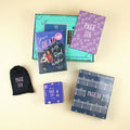 A new hardcover copy of You're Dead to Me, Reed Walker by Gwenyth Reitz sits on a green OUABC box. Also pictured are four wrapped gifts labeled with page numbers to open as you read!