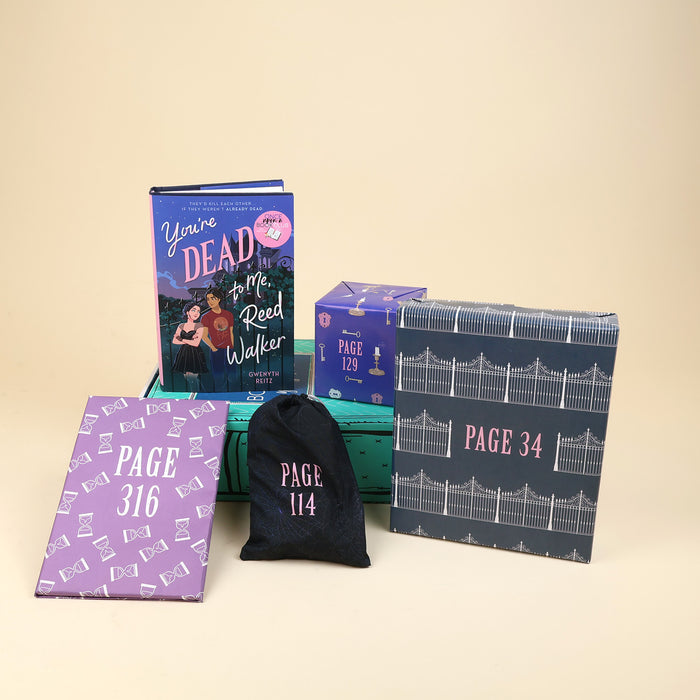 A new hardcover copy of You're Dead to Me, Reed Walker by Gwenyth Reitz sits on a green OUABC box. Also pictured are four wrapped gifts labeled with page numbers to open as you read!