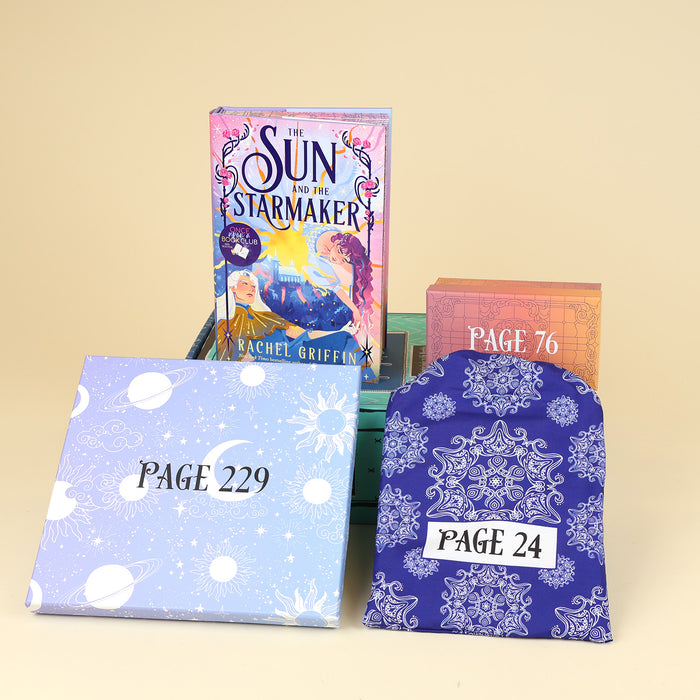 A hardcover edition of The Sun and the Starmaker stands on a green OUABC box next to a box labeled with a page number. In front of the box are two more wrapped gifts in various patterns labeled with page numbers.